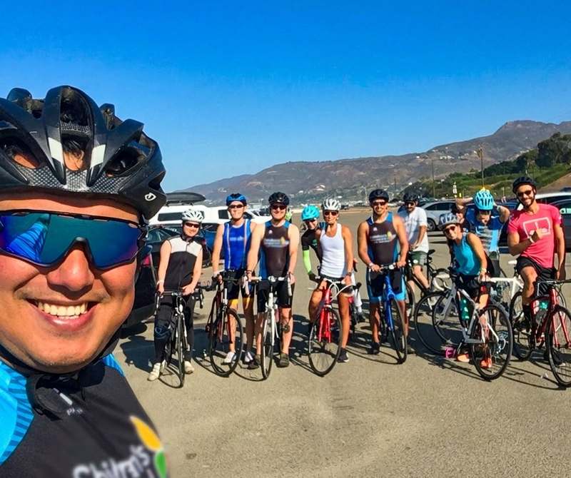 Coach Marlon selfie with triathlon training group ride at Malibu beach parking lot