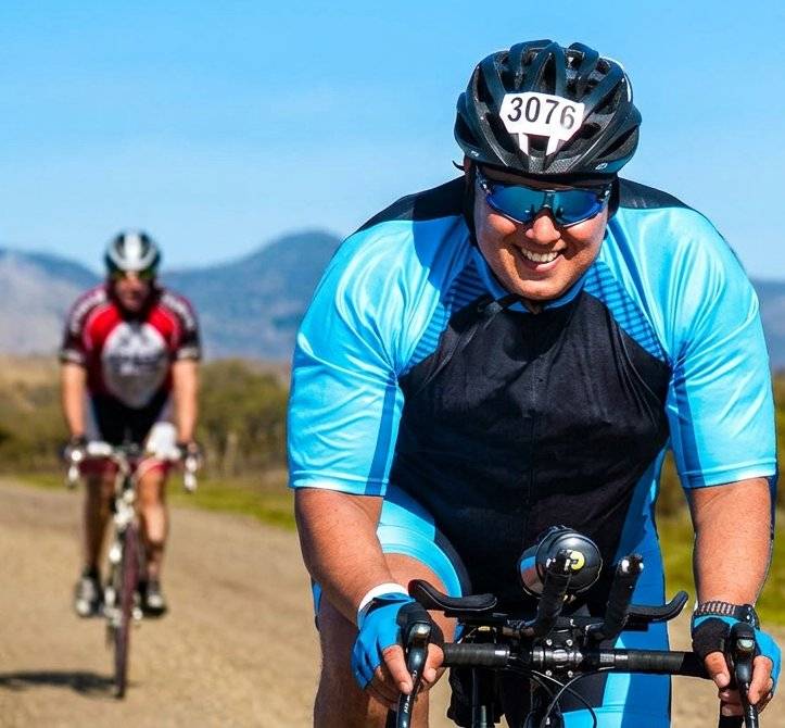 Marlon Duarte racing on the bike, race number 3076, mountains in background