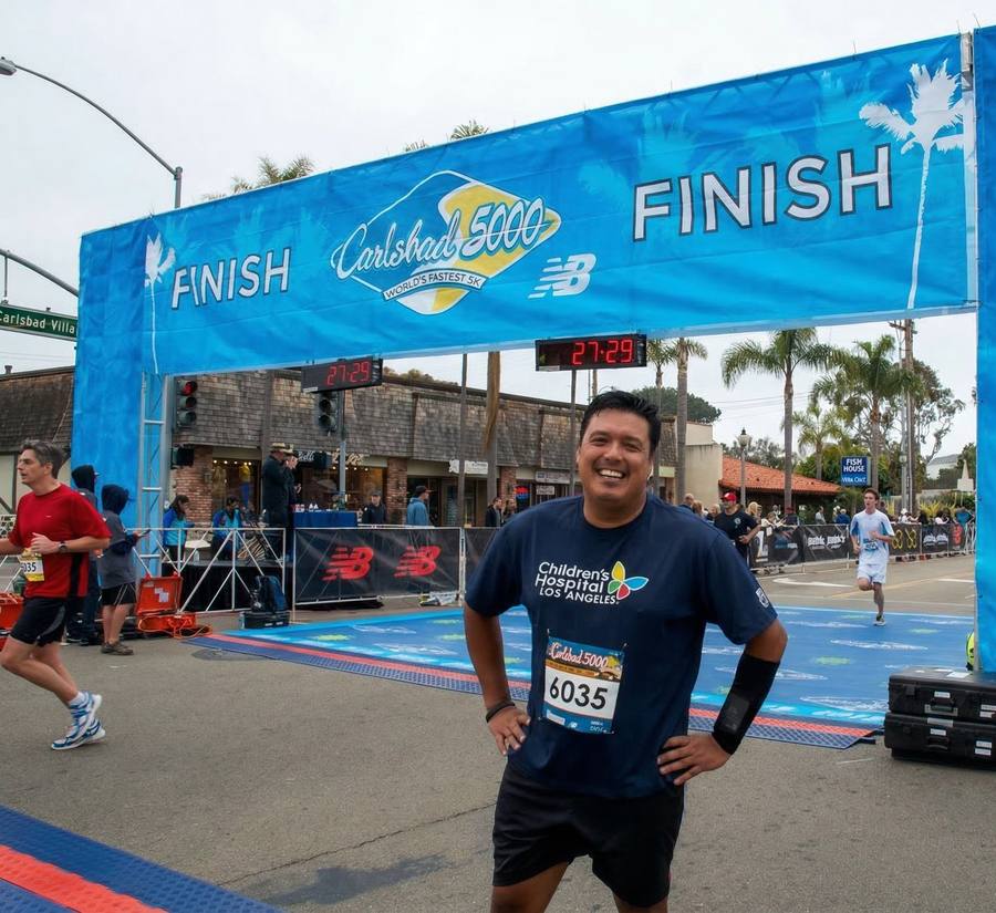 Marlon at Carlsbad 5000 finish line in CHLA jersey, bib #6035