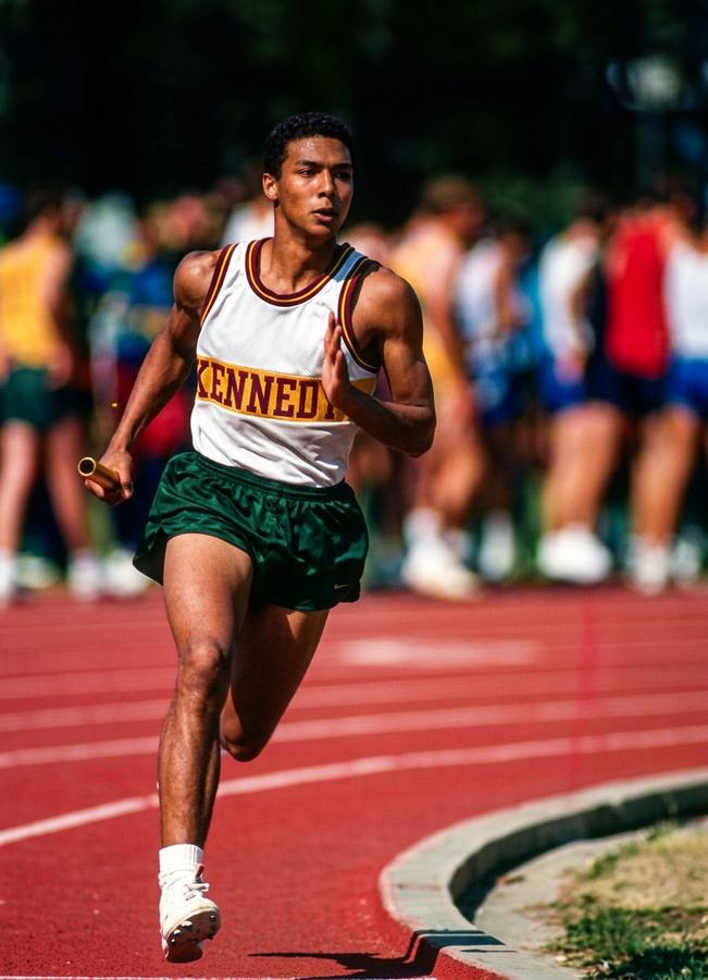 Marlon running the 1600m relay for Kennedy High School track team, baton in hand