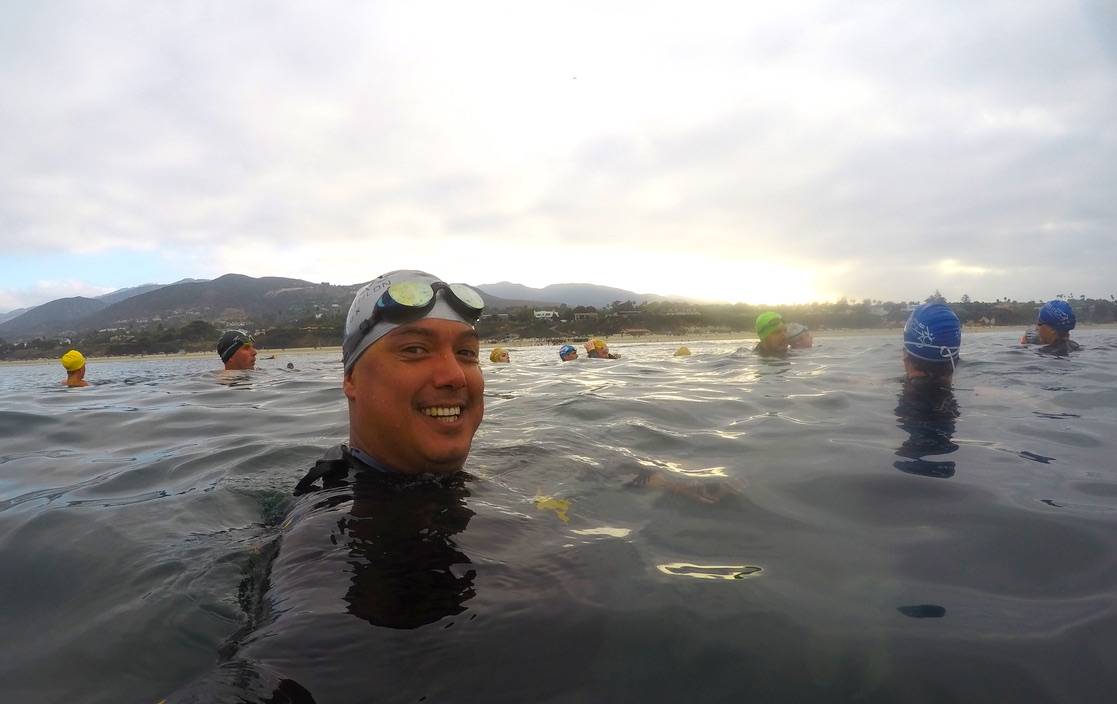 Coach Marlon open water swimming with athletes at dawn